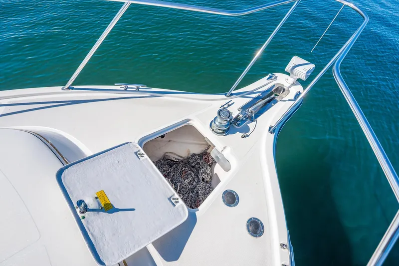 Slide: The Image of Bow of 2000 Tiara 31 Open boat with anchor chain compartment, on calm water. - 26