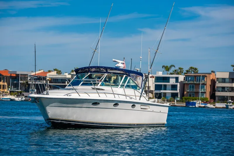 Slide: The Image of 2000 Tiara 31 Open boat on water, with coastal buildings in the background. - 32
