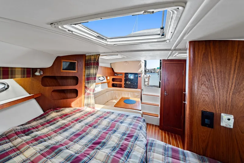 Slide: The Image of Interior of 2000 Tiara 31 Open yacht with plaid bedding and wooden accents. - 5