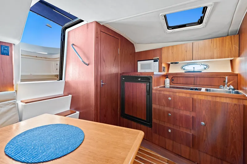 Slide: The Image of Interior of 2000 Tiara 31 Open yacht with kitchenette and wooden cabinetry. - 8