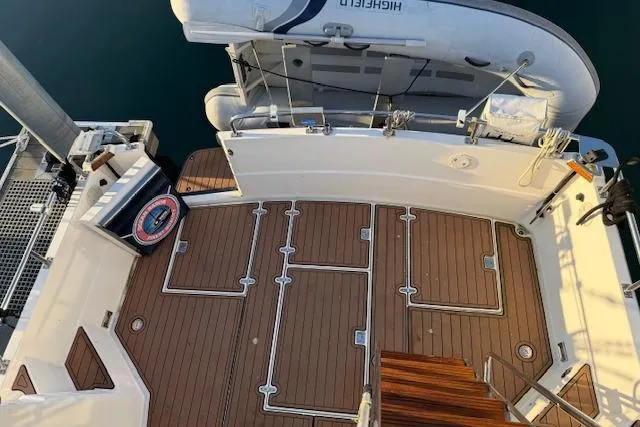 Slide: The Image of 2001 Sabreline Sedan boat deck with wooden flooring and attached dinghy. - 16