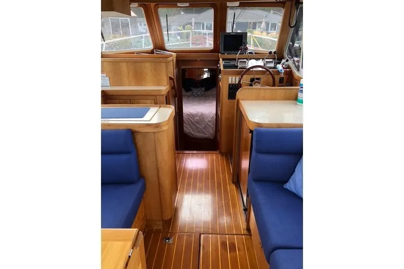 Slide: The Image of Interior of a 2001 Sabreline Sedan boat with wooden flooring and blue seating. - 20