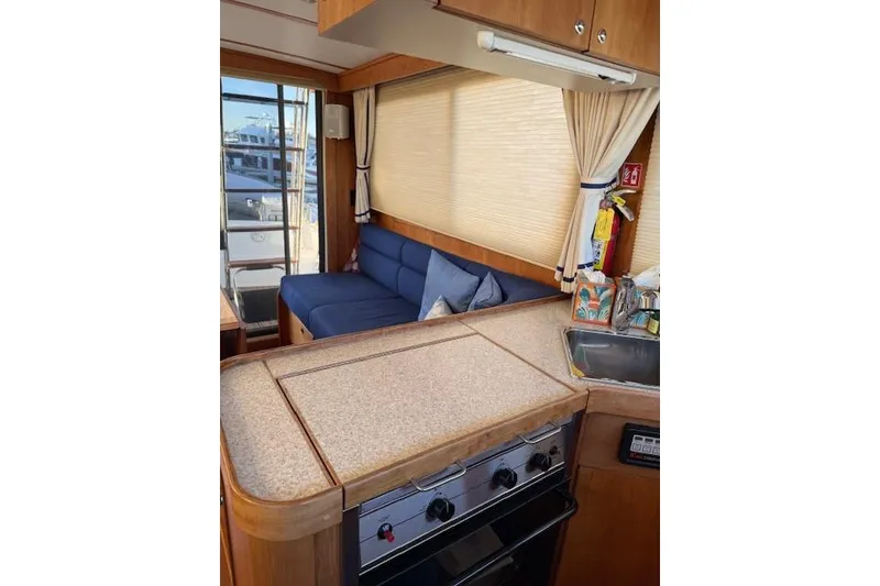 Slide: The Image of Interior of 2001 Sabreline Sedan with kitchen and seating area, featuring wood finishes. - 30