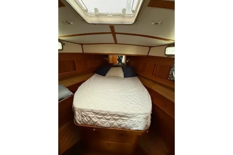 Slide: The Image of 2001 Sabreline Sedan cabin interior with cozy bed and wooden finish. - 38