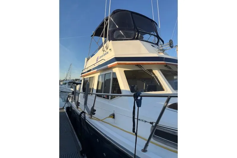 Slide: The Image of 2001 Sabreline Sedan boat docked, featuring a sleek design and spacious upper deck. - 6