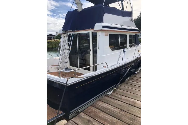 Slide: The Image of 2001 Sabreline Sedan boat docked, featuring a blue and white exterior with a ladder. - 9