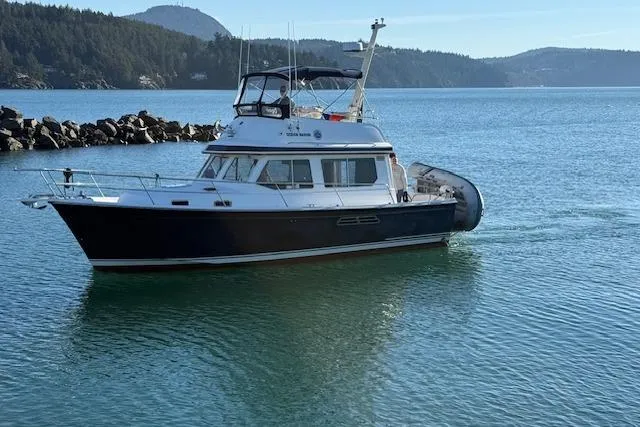 Slide: The Image of 2001 Sabreline Sedan boat cruising in scenic coastal waters. - 12