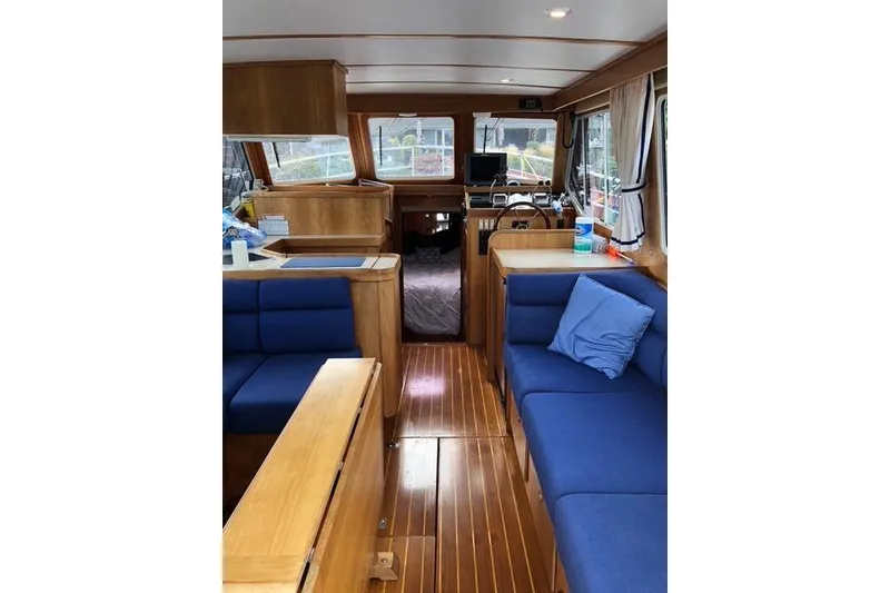 Slide: The Image of Interior of 2001 Sabreline Sedan boat with wooden finish and blue seating. - 2