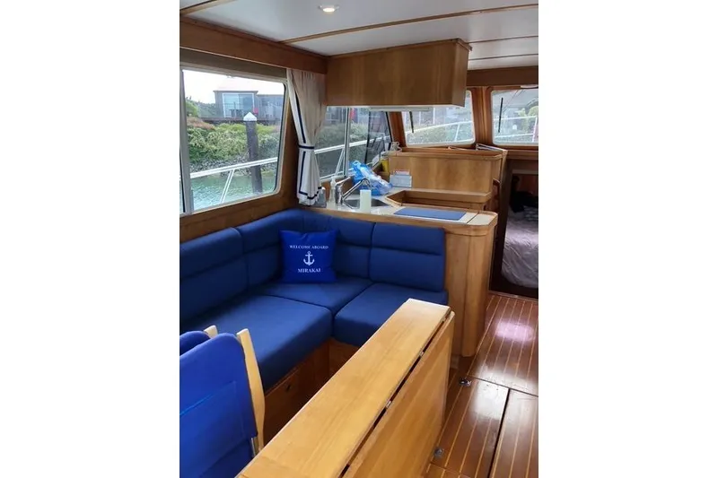 Slide: The Image of Interior of 2001 Sabreline Sedan boat with blue seating and wooden finishes. - 21