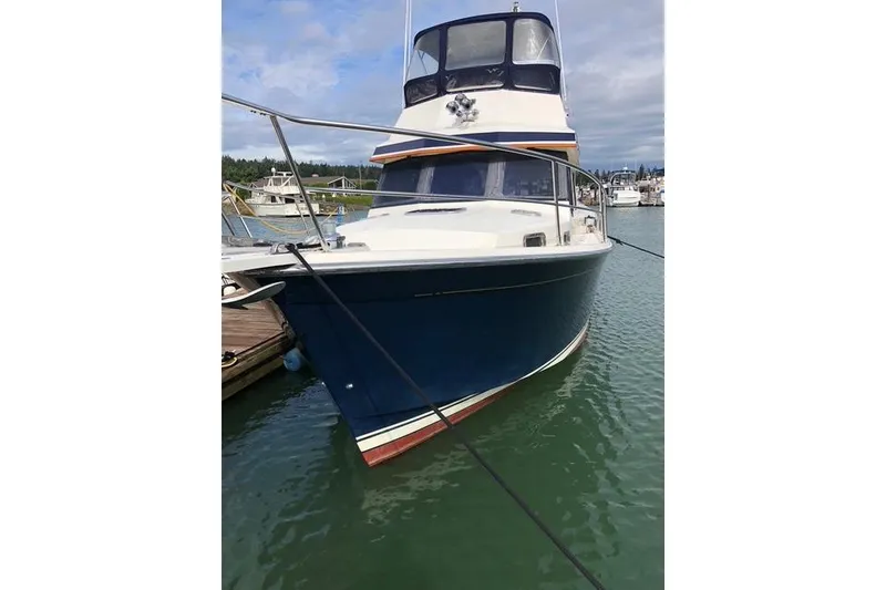 Slide: The Image of 2001 Sabreline Sedan boat docked in marina, featuring a sleek blue hull. - 4