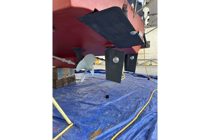 Slide: The Image of 2001 Sabreline Sedan boat underside with propeller and rudder on blue tarp. - 59