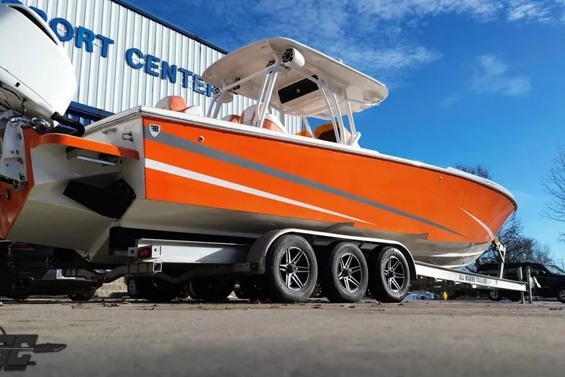 Slide: The Image of 2021 Avanti 36 Center Console boat in vibrant orange on a trailer at a sport center. - 20