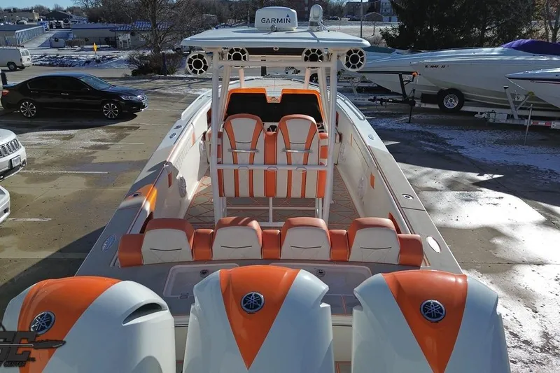 Slide: The Image of 2021 Avanti 36 Center Console boat with orange and white seating, docked outdoors. - 24