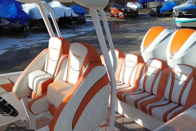 Slide: The Image of 2021 Avanti 36 Center Console boat with orange and white seating in a marina. - 36