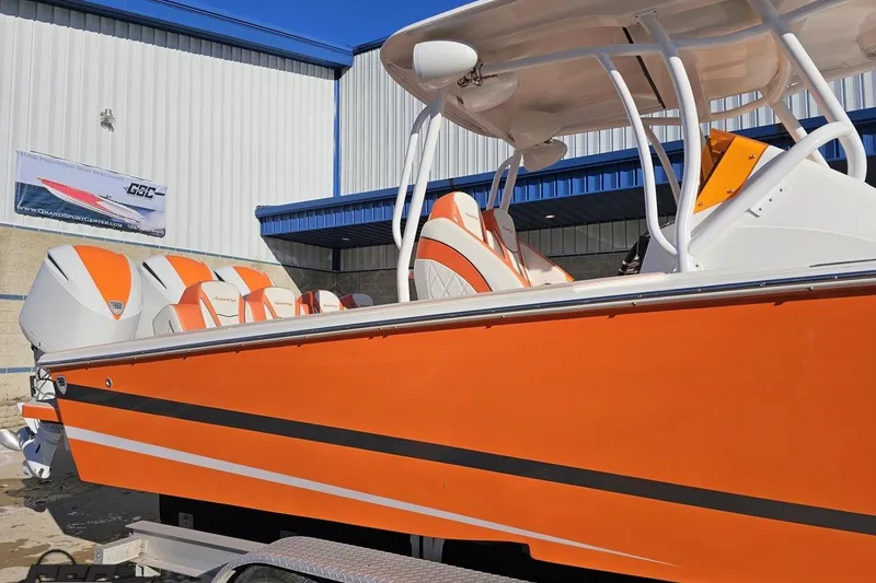 Slide: The Image of 2021 Avanti 36 Center Console boat with vibrant orange and white design, docked outdoors. - 6