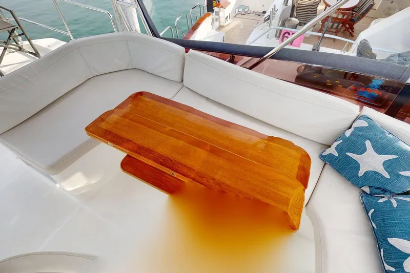 Slide: The Image of Cozy seating area on 2021 Beneteau Swift Trawler 35 with wooden table and starfish cushions. - 19