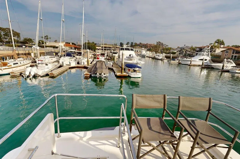 Slide: The Image of Beneteau Swift Trawler 35, 2021, docked in a marina with surrounding boats. - 22