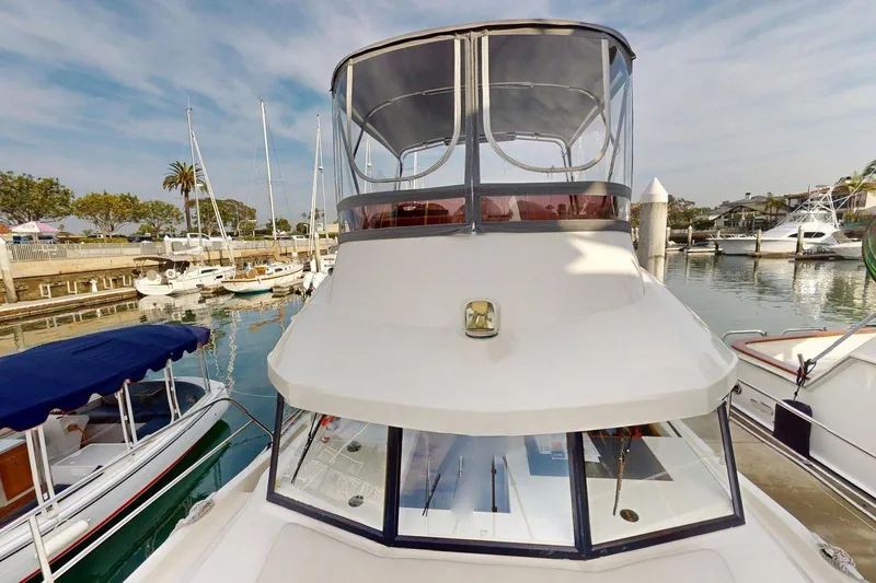 Slide: The Image of 2021 Beneteau Swift Trawler 35 docked in a marina, surrounded by other boats. - 24
