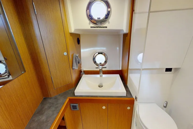 Slide: The Image of Bathroom interior of 2021 Beneteau Swift Trawler 35 with sink and porthole window. - 27