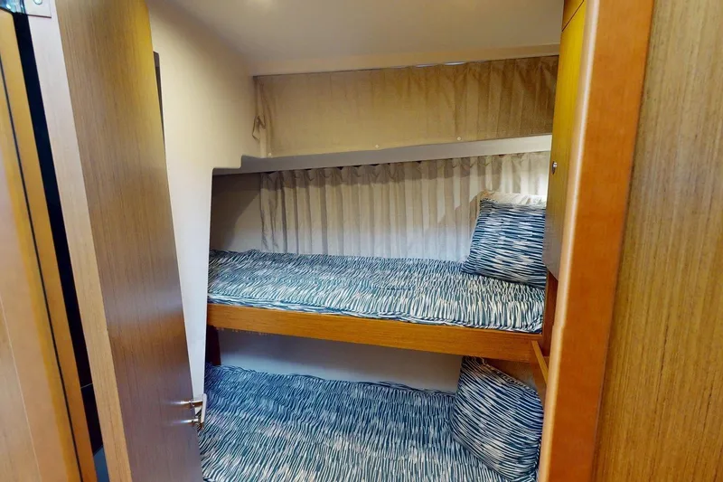 Slide: The Image of 2021 Beneteau Swift Trawler 35 cabin with bunk beds and patterned bedding. - 30