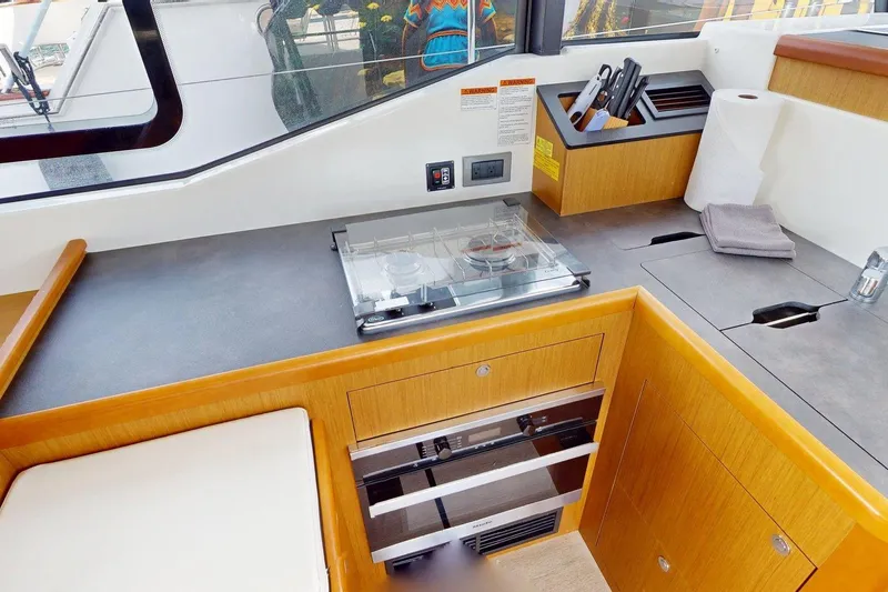 Slide: The Image of Modern kitchen area in 2021 Beneteau Swift Trawler 35 with stove and storage. - 34