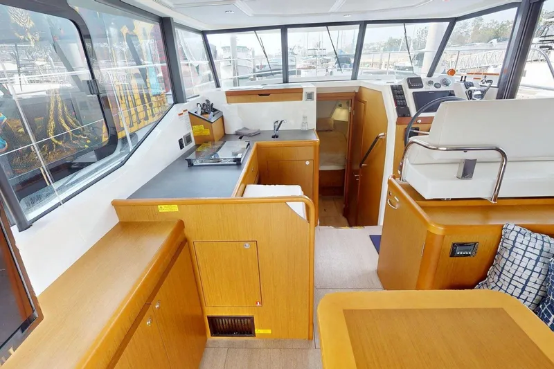 Slide: The Image of Interior of 2021 Beneteau Swift Trawler 35, featuring modern wood cabinetry and helm station. - 37