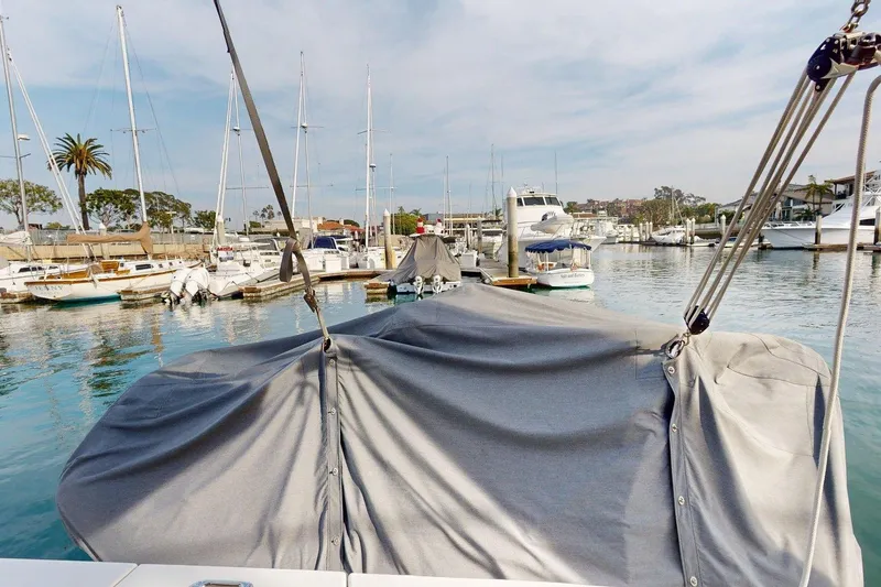 Slide: The Image of 2021 Beneteau Swift Trawler 35 docked in a marina, covered with a protective tarp. - 39
