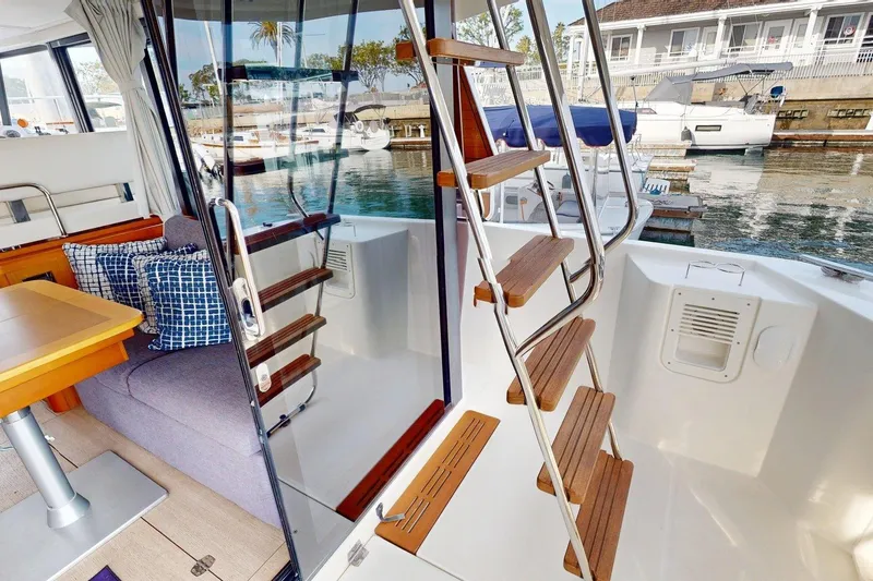 Slide: The Image of Interior view of 2021 Beneteau Swift Trawler 35, featuring wooden stairs and cozy seating area. - 40