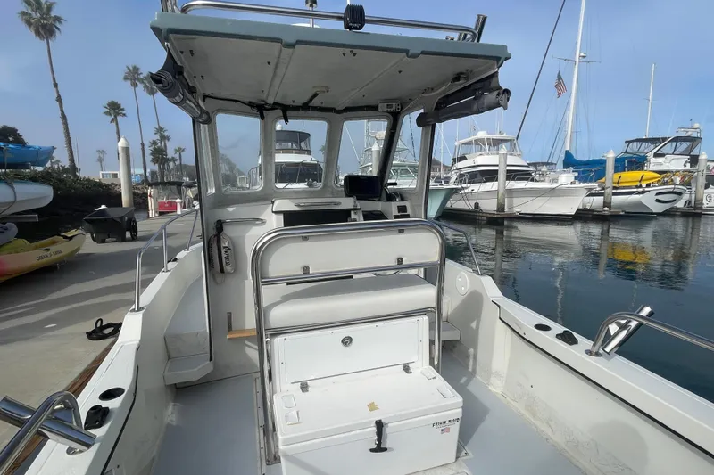 Slide: The Image of 1993 Davis Radoncraft boat docked at marina, surrounded by yachts and palm trees. - 16