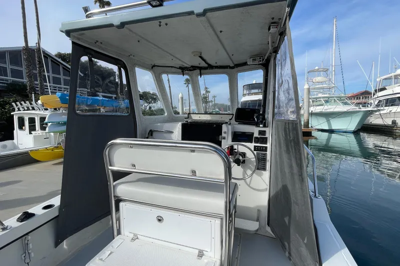 Slide: The Image of 1993 Davis Radoncraft boat interior at marina, featuring helm and seating area. - 17