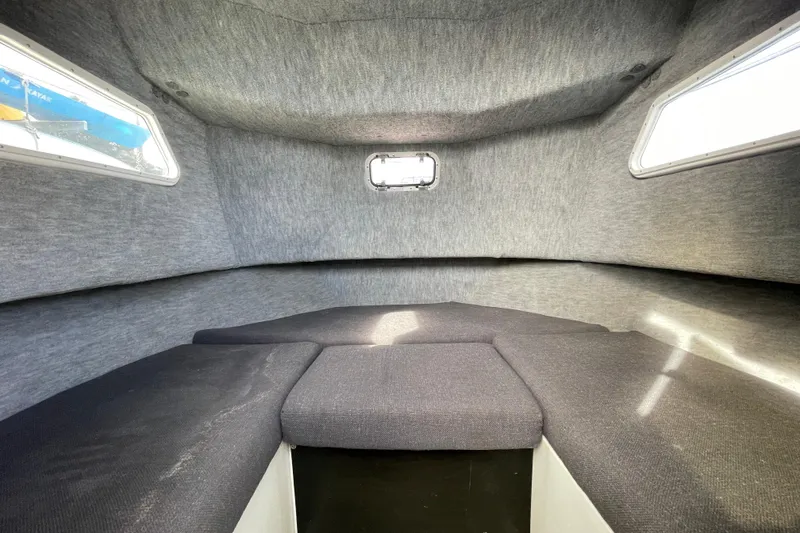 Slide: The Image of Interior cabin of a 1993 Davis Radoncraft boat with cushioned seating and windows. - 33