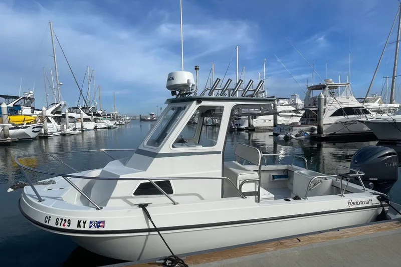 Slide: The Image of 1993 Davis Radoncraft boat docked at a marina, surrounded by other vessels. - 7
