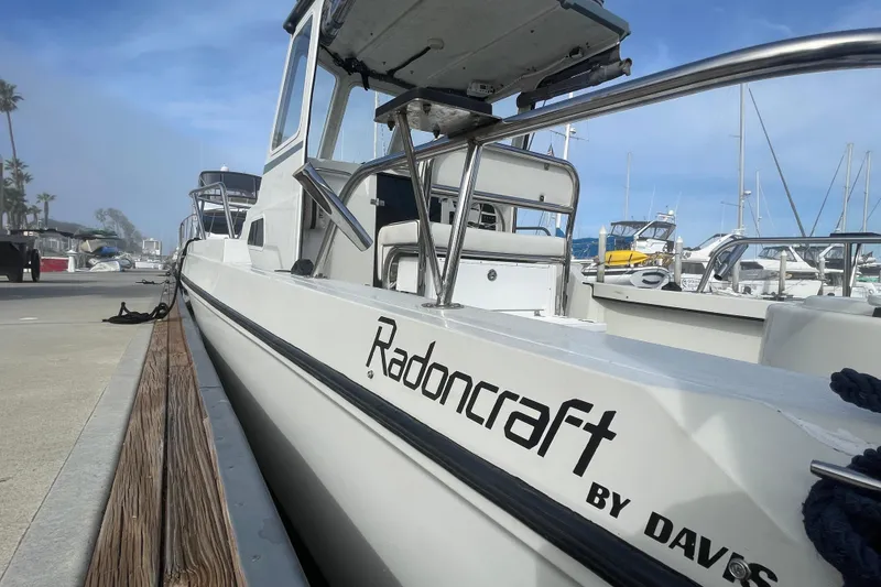 Slide: The Image of 1993 Davis Radoncraft boat docked at a marina, showcasing sleek design and branding. - 8