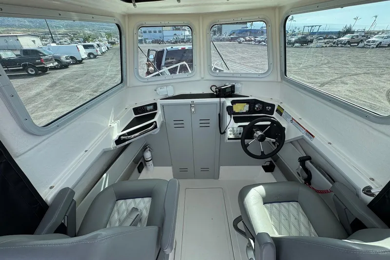 Slide: The Image of Interior of 2024 Arima Sea Chaser 19 Yellowtail Edition boat, featuring steering wheel and seating. - 16