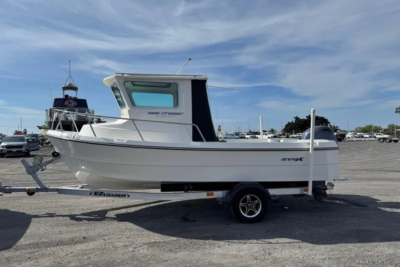 Slide: The Image of 2024 Arima Sea Chaser 19 Yellowtail Edition boat on trailer, parked outdoors. - 8