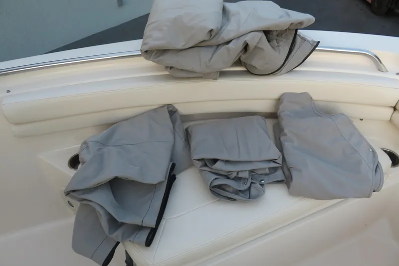 Slide: The Image of Gray boat covers on a 2016 Grady-White Fisherman 209's white seating area. - 65