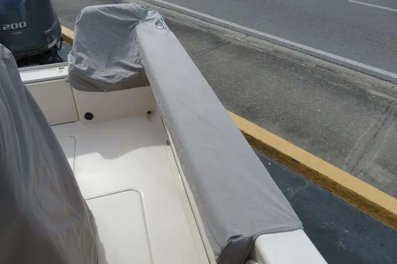 Slide: The Image of 2016 Grady-White Fisherman 209 boat with protective covers, docked near a road. - 70