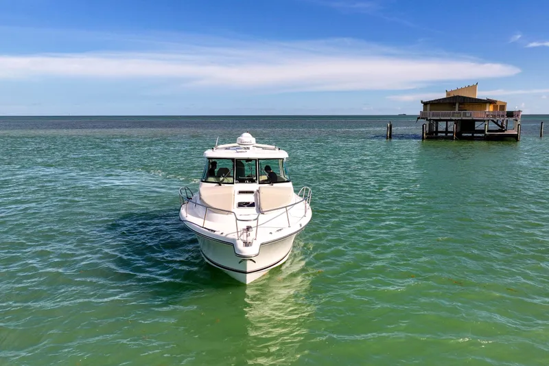 Slide: The Image of 2016 Pursuit OS 385 Offshore boat on turquoise water near a coastal structure. - 10