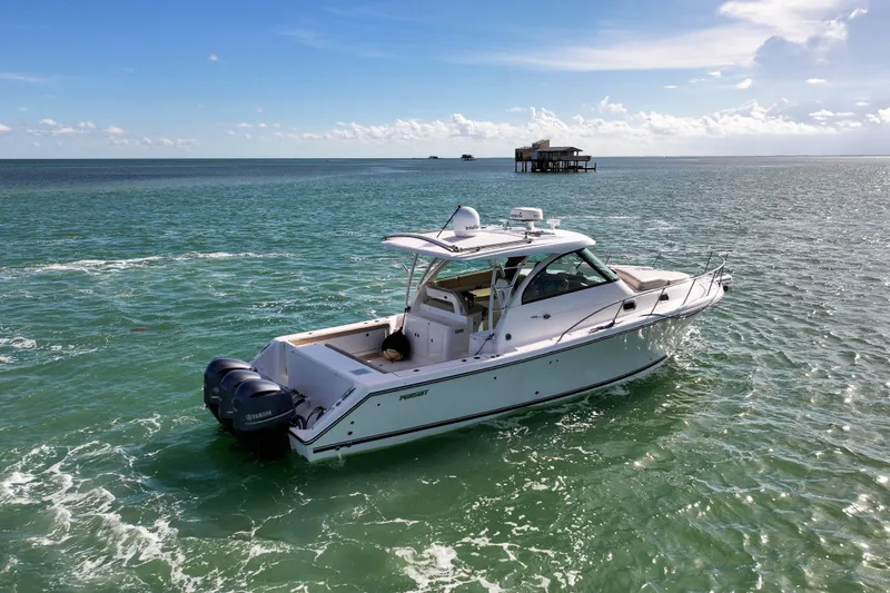 Slide: The Image of 2016 Pursuit OS 385 Offshore boat cruising on open water under a clear sky. - 13