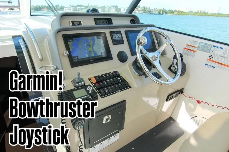 Slide: The Image of Helm of 2016 Pursuit OS 385 Offshore with Garmin navigation, bow thruster, and joystick controls. - 2