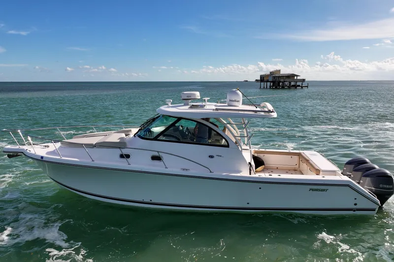 Slide: The Image of 2016 Pursuit OS 385 Offshore boat cruising on clear ocean waters. - 23