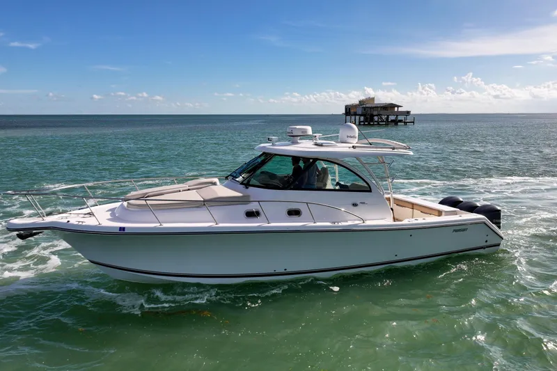 Slide: The Image of 2016 Pursuit OS 385 Offshore boat cruising on clear ocean waters. - 24