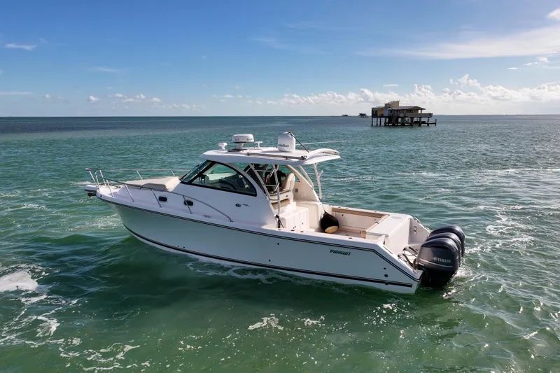 Slide: The Image of 2016 Pursuit OS 385 Offshore boat cruising on open water under clear skies. - 25