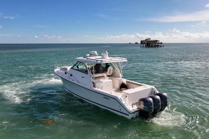 Slide: The Image of 2016 Pursuit OS 385 Offshore boat cruising on open water under clear blue skies. - 27