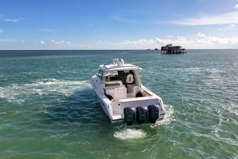 Slide: The Image of 2016 Pursuit OS 385 Offshore boat cruising on open water under clear skies. - 28