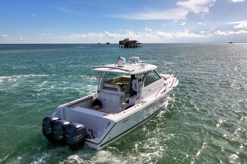 Slide: The Image of 2016 Pursuit OS 385 Offshore boat cruising on open water under a clear blue sky. - 29
