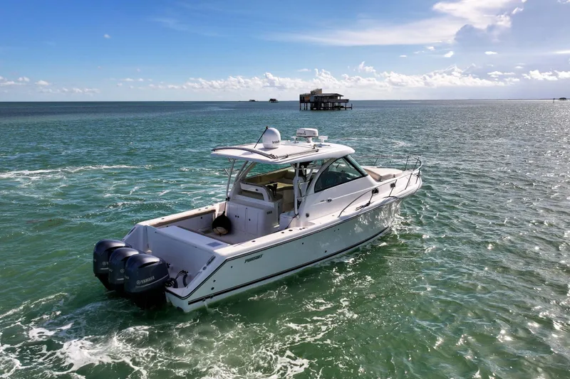Slide: The Image of 2016 Pursuit OS 385 Offshore boat cruising on open water under a clear sky. - 30