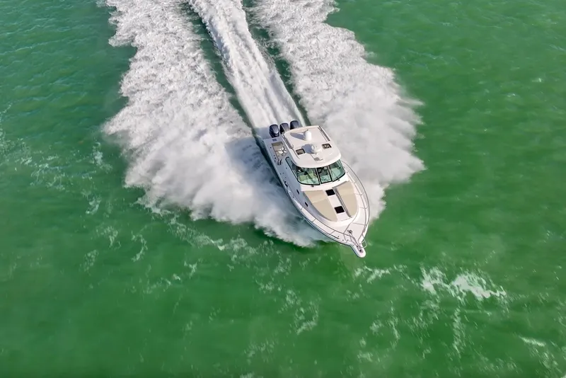 Slide: The Image of 2016 Pursuit OS 385 Offshore cruising on vibrant green water, aerial view. - 35