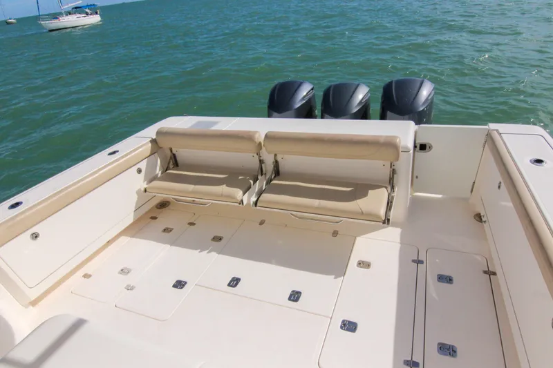 Slide: The Image of 2016 Pursuit OS 385 Offshore boat deck with seating and triple outboard motors. - 38