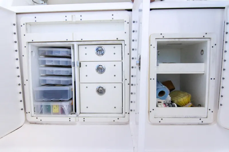 Slide: The Image of Storage compartments on a 2016 Pursuit OS 385 Offshore boat, featuring organized drawers and shelves. - 40